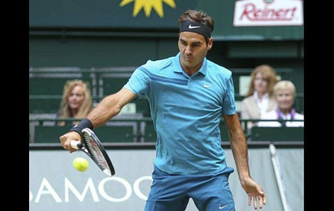 Roger Federer returns the ball to Matthew Ebden during their match at the Gerry Weber Open tennis tournament in Halle. | AP