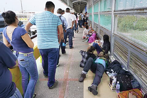 In this Thursday, June 23, 2018 photo, migrant families rest from their travels to Matamoros, Mexico, along Gateway International Bridge which connects to Brownsville, Texas, as they seek asylum in the United States. | AP