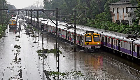 Suburban trains chug on water-logged tracks during heavy rains in Mumbai (Photo | PTI)