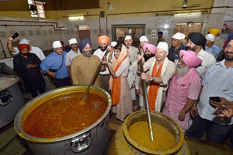 US envoy to the UN Nikki Haley and US Ambassador to India Kenneth Juster participate in langar seva as Delhi Sikh Gurdwara Management Committee DSGMC President Manjit Singh GK in blue turban looks on during a visit to Gurudwara Sis Ganj Sahib in Chandni C