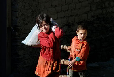 Pakistani children salvage what the can from their destroyed homes caused by Monday's earthquake in Chitral town, northern Pakistan, Thursday, Oct. 29, 2015 | AP