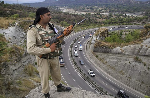 A paramilitary soldier stands guard as the first batch of pilgrims leaves for Amarnath Yatra in Jammu. ( Photo | PTI)