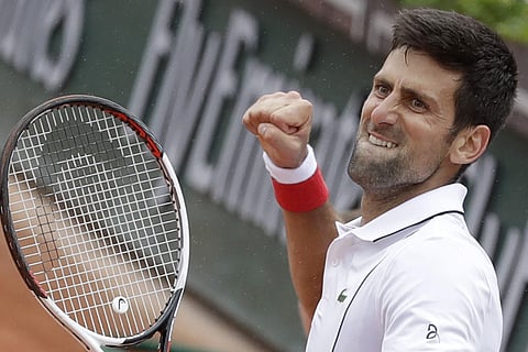 Novak Djokovic clenches his fist after scoring a point against Roberto Bautista Agut during their third round match of the French Open tennis tournament at the Roland Garros stadium in Paris, France. | AP