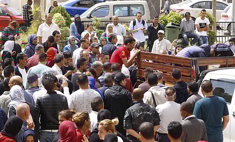 People wait to receive the bodies of loved ones after the sinking of a boat carrying migrants in the coastal city of Sfax, Tunisia. | AP