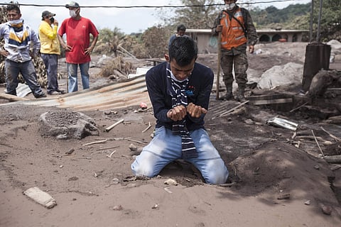 Bryan Rivera cries after looking at the remains of his house, after his family went missing during the Volcan de Fuego or 'Volcano of Fire' eruption, in San Miguel Los Lotes, Guatemala. (AP)
