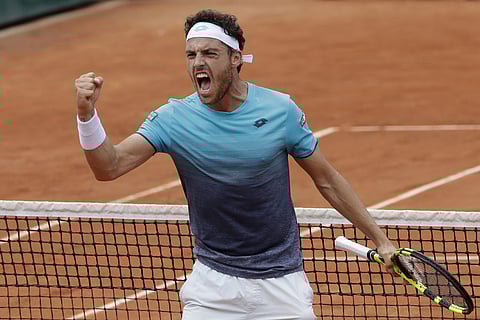 Italy's Marco Cecchinato celebrates winning the second set against Serbia's Novak Djokovic during their quarterfinal match of the French Open tennis tournament at the Roland Garros stadium in Paris. | AP