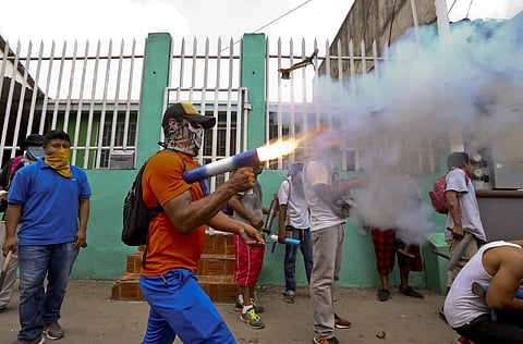 A masked protester shoots off his homemade mortar in the Monimbo neighborhood during clashes with police. | AP