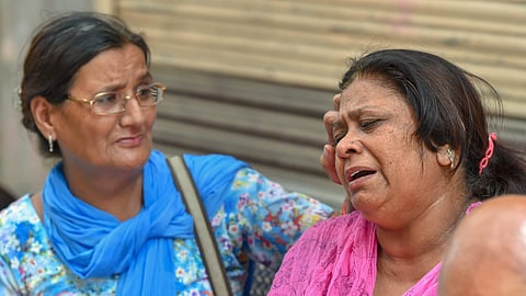 Relatives of the Bhatia family whose 11 members were found dead in their house on Sunday outside their house at Burari in New Delhi. (Photo | PTI)