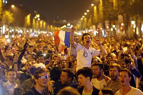 People celebrate on the Champs Elysees avenue after the semifinal match between France and Belgium at the 2018 soccer World Cup, Tuesday, July 10, 2018 in Paris. | AP