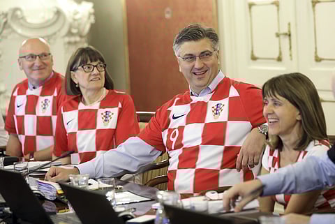 Croatia's Prime Minister Andrej Plenkovic, center, sits between ministers wearing Croatian national soccer team jerseys during during a government session in Zagreb, Croatia. (Photo | AP)