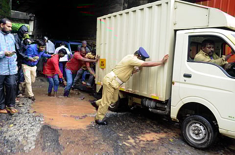 Many hands try to make light work of the pothole under the Railway Overbridge at Temple Road. (A Sanesh | EPS)