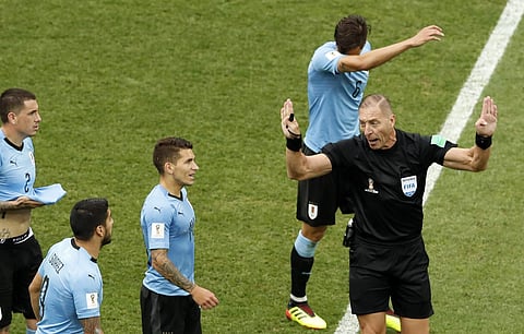 Referee Nestor Pitana right, gestures to the Uruguayan players during the quarterfinal match between Uruguay and France at the 2018 soccer World Cup in the Nizhny Novgorod Stadium, in Nizhny Novgorod, Russia, Friday, July 6, 2018. | AP