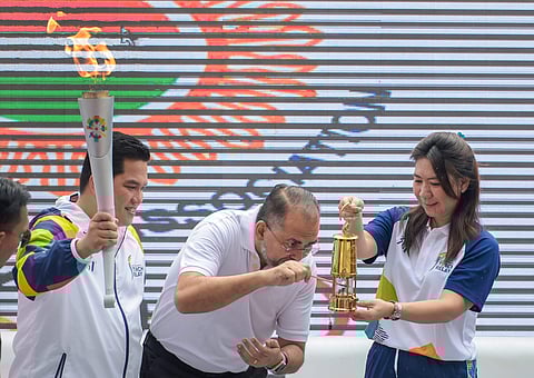 From left- Erick Thohir Chairman Indonesia Asian Games Organizing Committee INASGOC Indonesia's ambassador to India Sidharto Reza Suryodipuro and Badminton legend Susi Susanti Torch Ambassador from Indonesia light the torch during the 18th Asian Games Jak
