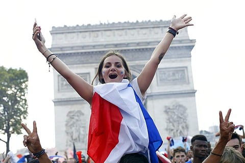 French soccer fans react on the Champs Elysees avenue with the Arc de Triomphe on background, after defeated Croatia in the final match at the 2018 soccer World Cup, in Paris, France, Sunday, July 15, 2018. France won the final 4-2. (Photo | AP)