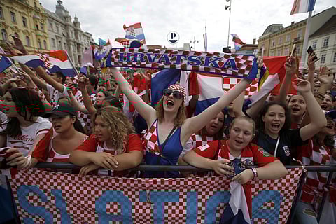 Supporter of Croatia national soccer team members wait to welcome the team on their arrival in Zagreb. | AP