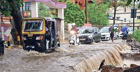 A man clearing water from his house in Jaydurga Nagar