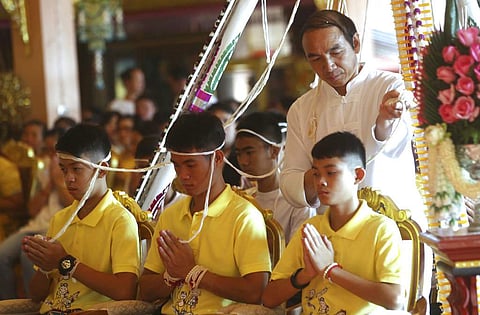 Coach Ekkapol Janthawong, center, and members of the rescued soccer team attend a Buddhist ceremony that is believed to extend the lives of its attendees as well as ridding them of dangers and misfortunes in Mae Sai district, Chiang Rai province, northern