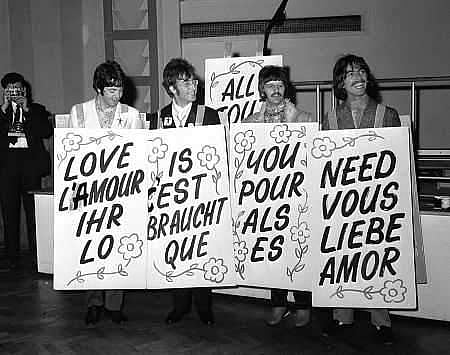 A 1967 photo of the Beatles holding up signs that say 'All you need is love' in different languages. (Photo | IMDB)