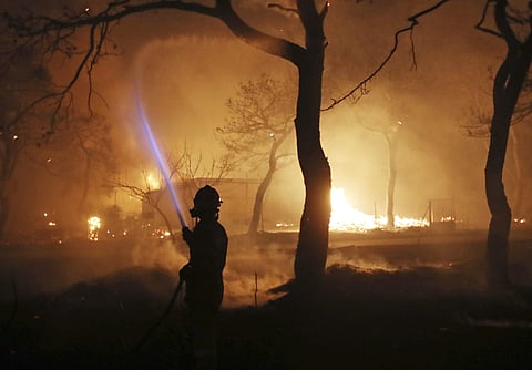 A firefighter sprays water on the fire in the town of Mati, east of Athens, Monday, July 23, 2018. Regional authorities have declared a state of emergency in the eastern and western parts of the greater Athens area as fires fanned by gale-force winds rage