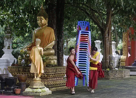 Thai Buddhist monks carry chairs to prepare for the rescued young soccer teammates and their coach in Mae Sai district, Chiang Rai province, northern Thailand, Tuesday, July 24, 2018. | Associated Press