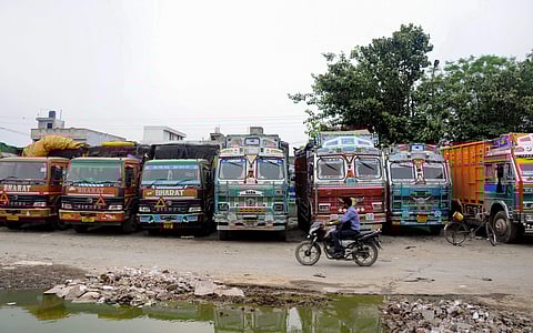 Goods trucks across India have come to a standstill over the past four days, as a protest against unfulfilled demands put forth by truckers. IN PIC: A motorist rides past trucks parked at Jahaj Ghar in Amritsar. (Photo | PTI)