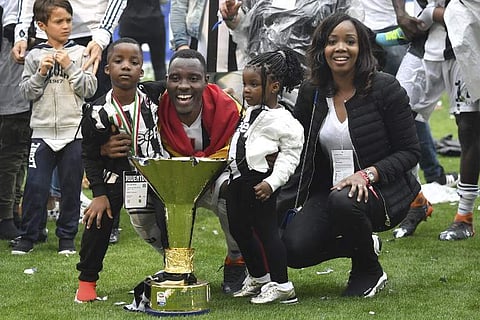 Kwadwo Asamoah and his family pose with the trophy during the victory ceremony following the Italian Serie A last football match of the season Juventus versus Verona. (File | AFP)