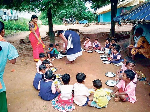Children having meals in open at an anganwadi centre in Nabarangpur district | Express