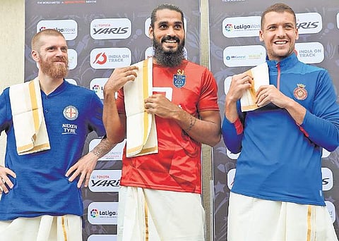 Melbourne City FC’s Luke Brattan, Kerala Blasters captain Sandesh Jhingan & Girona FC skipper Alex Granell draped in traditional Kerala mundu. (Photo | EPS/ Melton Antony)