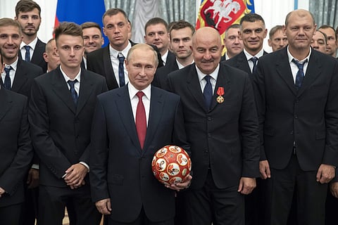Russian President Vladimir Putin, center left, and Russia's soccer team head coach Stanislav Cherchesov, center right, goalkeeper Igor Akinfeev, second row center, soccer players Alexander Golovin, second from left, Artem Dzyuba, second row third from lef