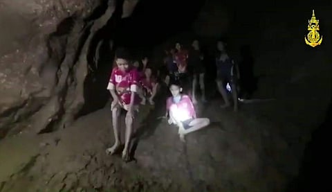 In this photo released by Tham Luang Rescue Operation Center, shows the boys and their soccer coach as they were found in a partially flooded cave, in Mae Sai, Chiang Rai, Thailand.