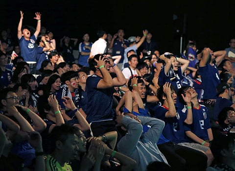 Supporters of Japan soccer team react as they watch a live broadcasting of the World Cup soccer match between Japan and Belgium at a public viewing venue in Tokyo. (AP)
