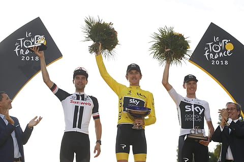 Britain's Geraint Thomas, wearing the overall leader's yellow jersey, second place Netherlands' Tom Dumoulin, left, and third place Britain's Chris Froome, right, celebrate on the podium after the twenty-first stage of the Tour de France. (Photo | AP)