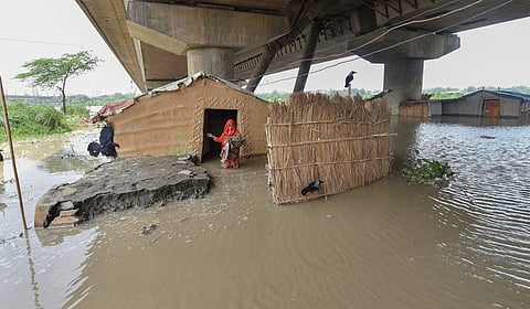 A woman stands outside her submerged shanty at Yamuna Khadar as the water level of Yamuna river rises in New Delhi on Sunday July 29 2018. | PTI