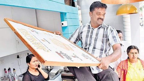 BBMP health officials removing non-Kannada boards at Forum Mall in Koramangala on Monday