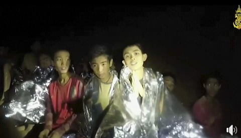In this July 3, 2018, image taken from video provided by the Thai Navy Seal, Thai boys are with Navy SEALs inside the cave, Mae Sai, northern Thailand. With heavy rains forecast to worsen flooding in a cave in northern Thailand where 12 boys and their soc