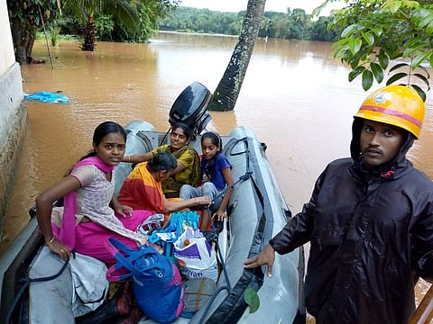 Fire service personnel rescuing residents at Shibaroor, Soorinje near Mangaluru. (EPS | Rajesh Shetty)