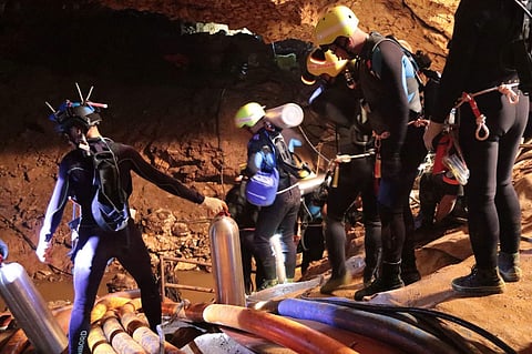 Thai rescue team members walk inside a cave where the boys are trapped. (Photo | AP)
