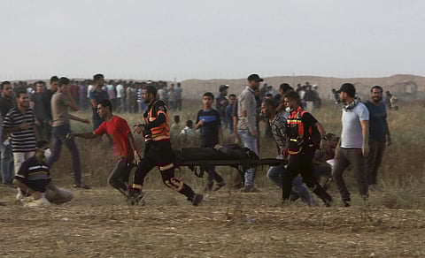 A file image of Palestinian medics and protesters evacuating a wounded woman near the Gaza Strip's border with Israel, during a protest east of Khan Younis. | AP