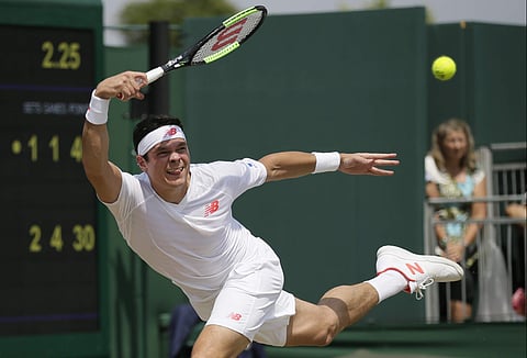 Milos Raonic of Canada plays a return to Mackenzie McDonald of the US during their men's singles match on the seventh day at the Wimbledon Tennis Championships in London. (AP)