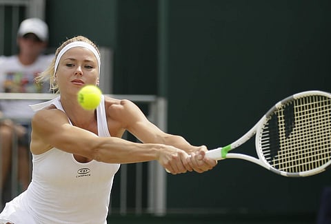 Italy's Camila Giorgi returns the ball to Russia's Ekaterina Makarova during their women's singles match, on day seven of the Wimbledon Tennis Championships, in London. (AP)