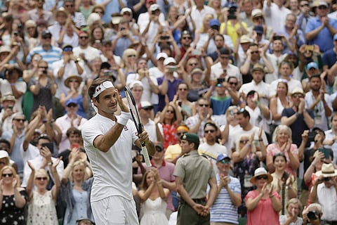 Roger Federer of Switzerland celebrates defeating France's Adrian Mannarino in their men's singles match, on day seven of the Wimbledon Tennis Championships, in London. (AP)