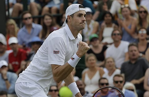 John Isner of the US celebrates winning a point from Stefanos Tsitsipas of Greece during their men's singles match on the seventh day at the Wimbledon Tennis Championships in London. (AP)