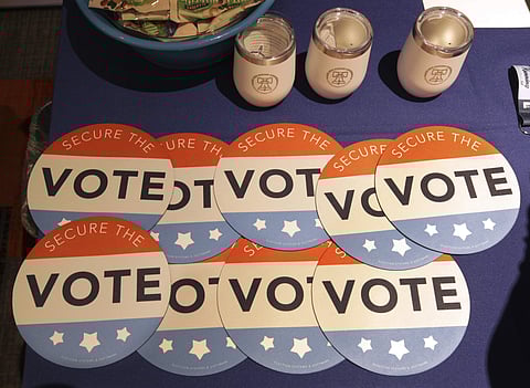 In this July 14, 2018, file photo, computer mouse pads with Secure the Vote logo on them are seen on a vendor's table at a convention of state secretaries of state in Philadelphia. As alarms blare about Russian interference in U.S. elections, the Trump ad