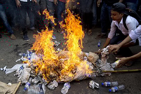 Bangladeshi students burn an effigy of Bangladesh's Shipping Minister Shahjahan Khan, who is also a transport workers' leader, as they block a road during a protest in Dhaka, Bangladesh. (Photo | AP)