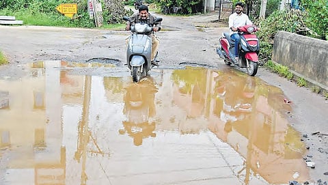 Commuters drive through a water-logged road at Nagarjuna Nagar in Vijayawada | R V K Rao