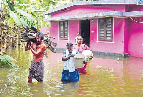 A family shifting firewood and essential items from their marooned house to a relative’s home, at Manjaly in Paravoor. Even after three days, flood water has not yet receded from several low-lying areas of Kochi (EPS | A Sanesh)