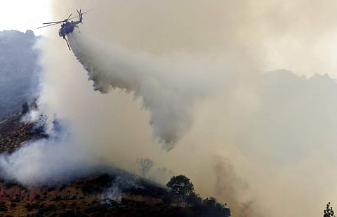 A helicopter drops water on to a wildfire Friday, Aug. 10, 2018, in Lake Elsinore, Calif. ( Photo | AP)