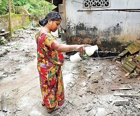 A woman cleaning up the premises of her house after the water receded at Eloor in Kochi on Sunday |  Melton Antony