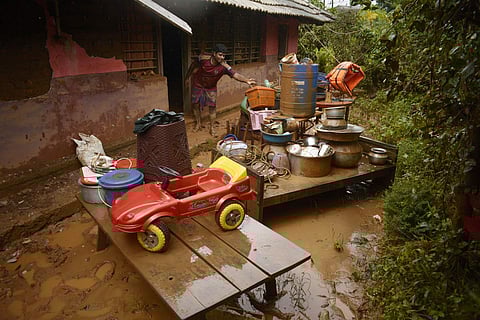 A resident retrieving the household items after the flood water entered his house in Wayanad.  (Photo | Manu R Mavelil/ EPS)