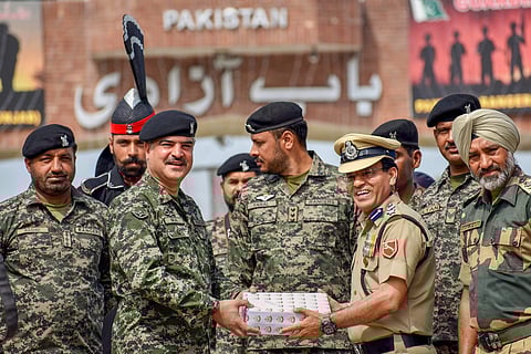 BSF Commandant Sudeep Kumar (R) presents sweets to Pakistani Wing Commander Bilal Ahmed (L) on the occasion of the Indian Independence Day at Attari-Wagah border post about 35 km from Amritsar on Wednesday August 15 2018. | PTI